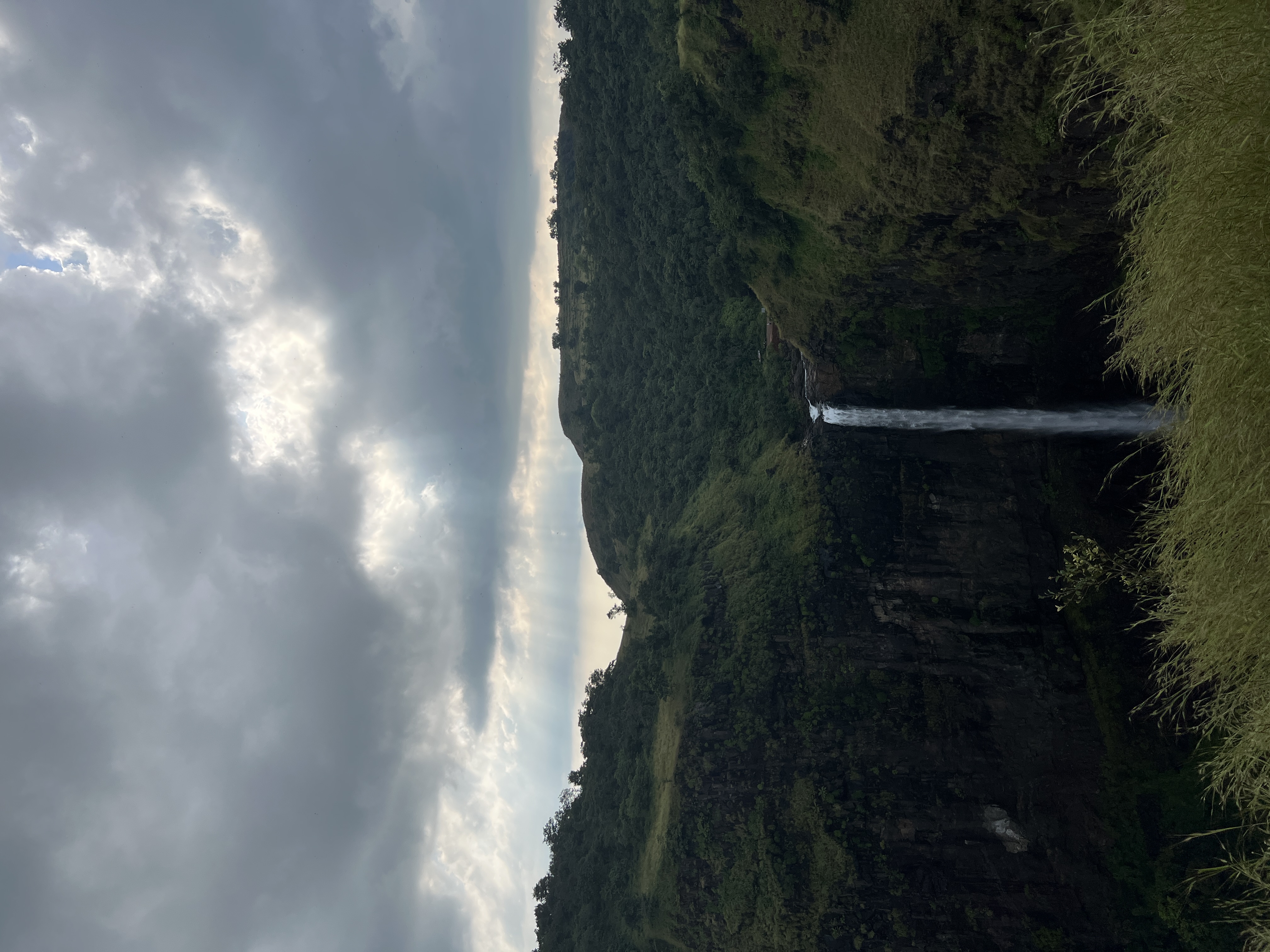 Waterfall framed against Sahyadri sky near Mitraay Resort