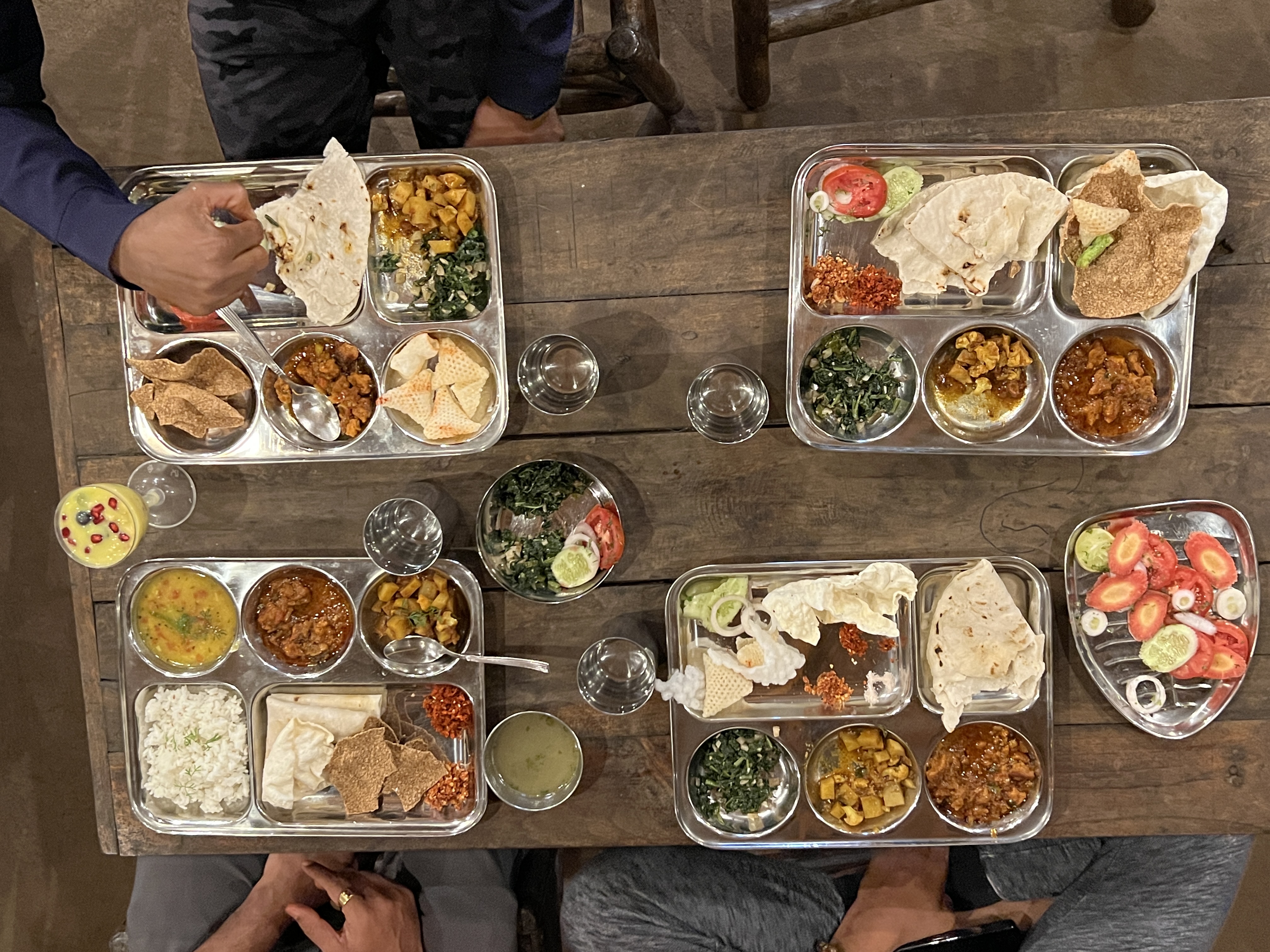 Traditional thali meal overhead view on wooden table at Mitraay Resort