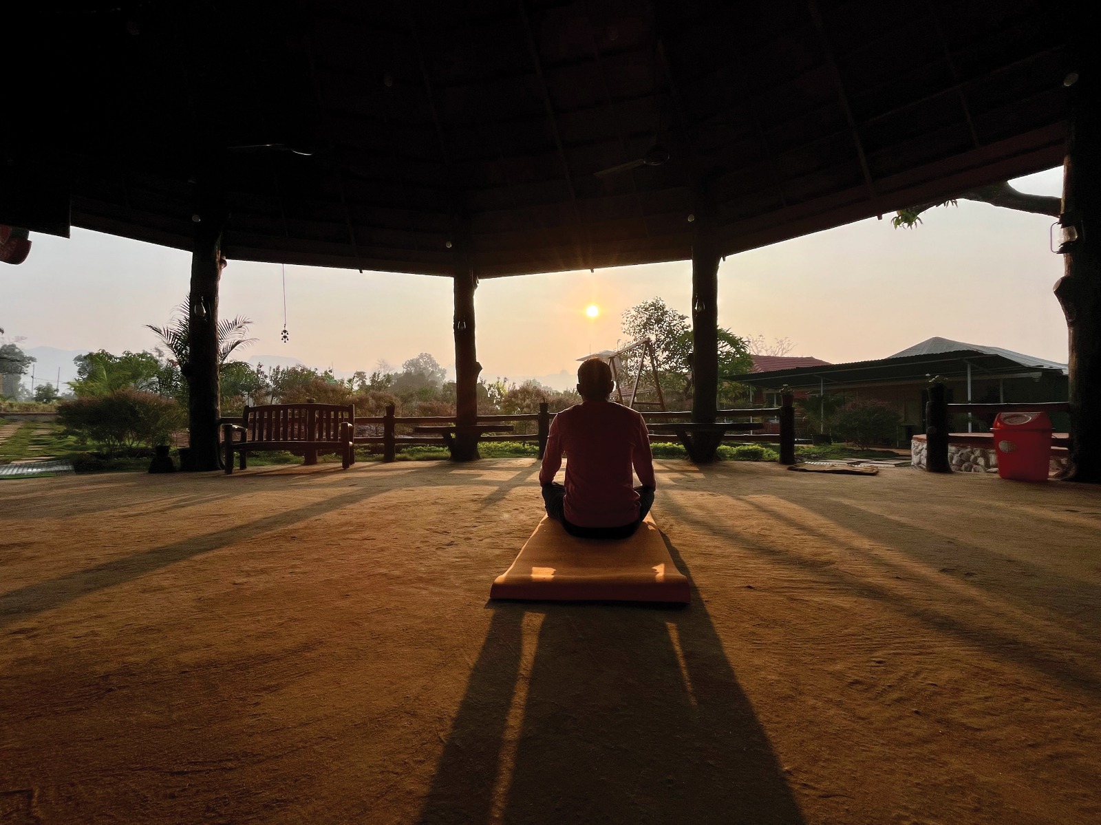 Meditation in the open pavilion at sunset at Mitraay Agro Resort