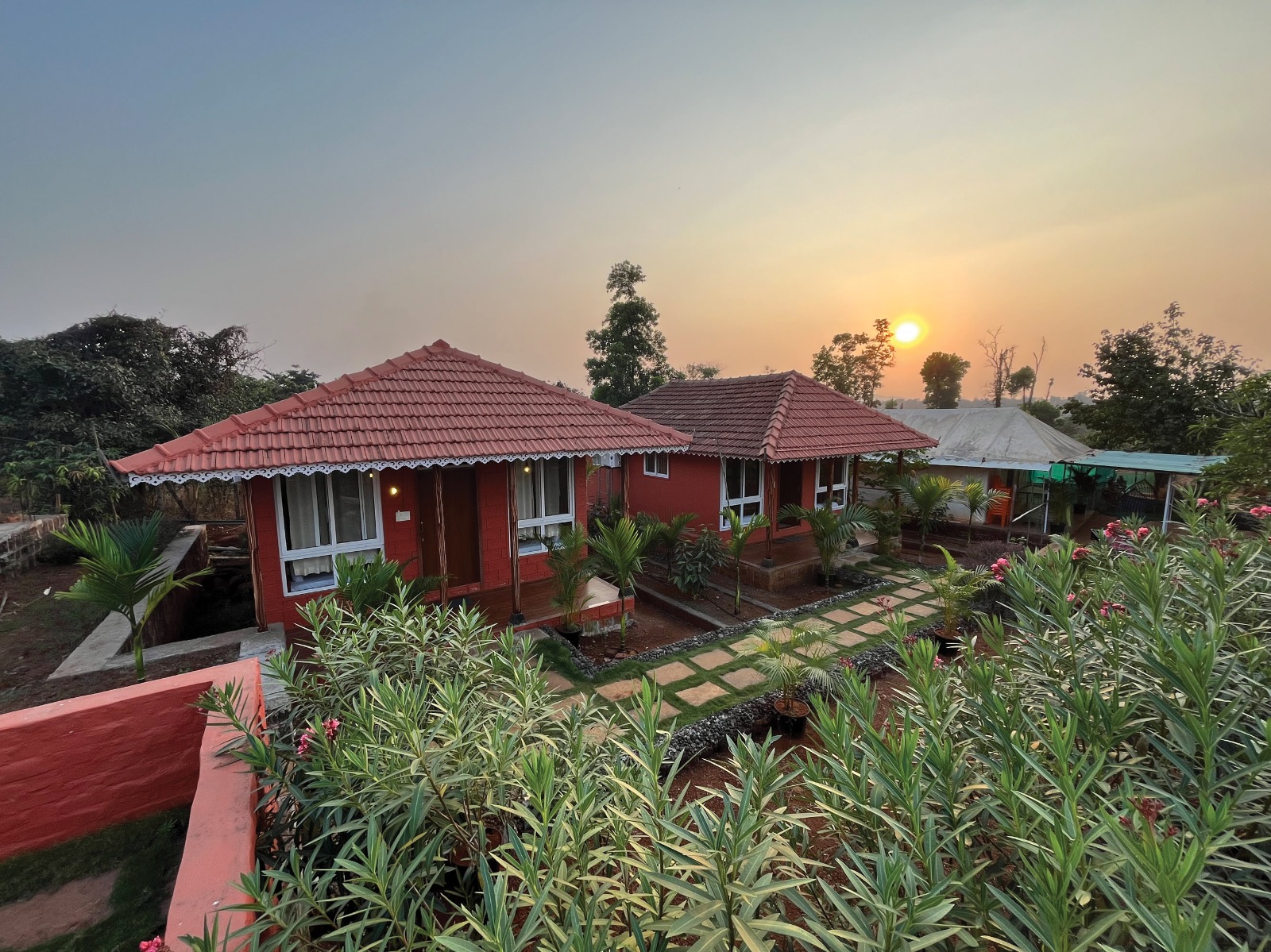 Stone huts with garden at golden hour at Mitraay Resort