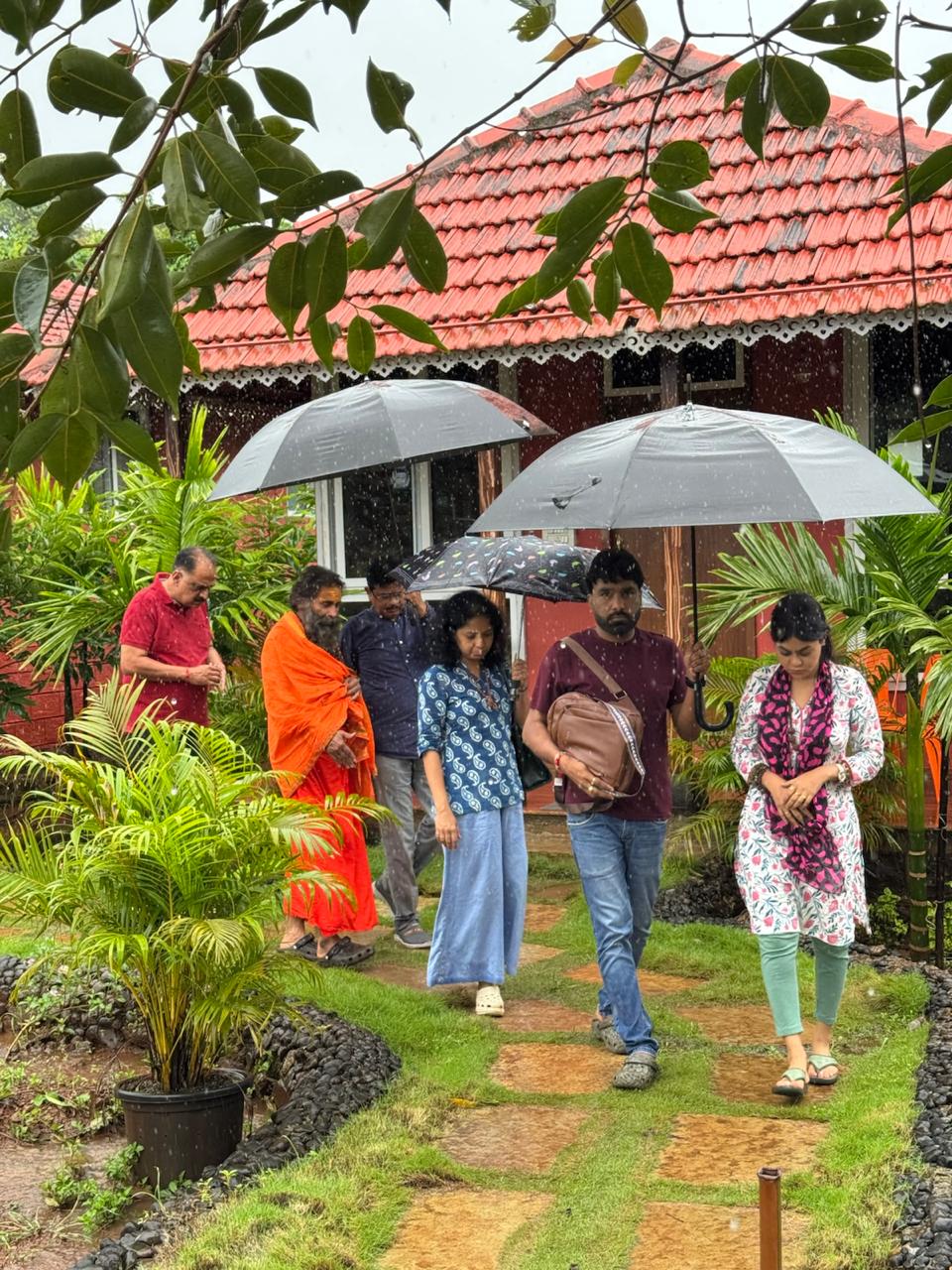 Group on a contemplative walk in the monsoon at Mitraay Resort